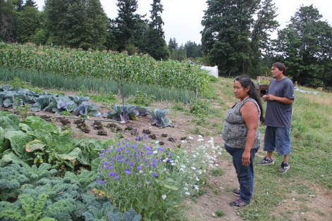 Grace Ann Byrd and Julian surveying kale and cabbages at the Nisqually Community Garden