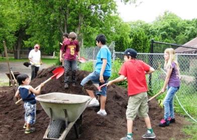 Kids helping to shovel 47 tons of compost, spring 2013. Photo courtesy of the Women's Environmental Institute