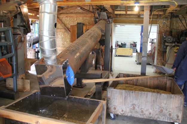 Device invented by Bruce to rub the hulls from the rice kernels. The rice is shoveled into a vent in the floor, drawn up a chute, and sent down this long tube. The inner workings of the tube are a proprietary secret....