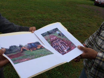 Danny Powless shows us photos of the construction of the hugelkultur bed last year. Photo of the photos by Elizabeth Hoover