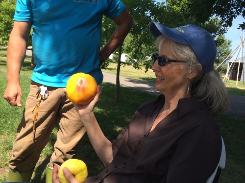 Diane Wilson, executive director, and Frank Haney, farm manager. Diane is holding two of the heritage tomato varieties Frank is grown on the farm-- on the left Great White Tomato (the only tomato indigenous to North America), and on the right a German Red Stripe tomato. Photo by Elizabeth Hoover