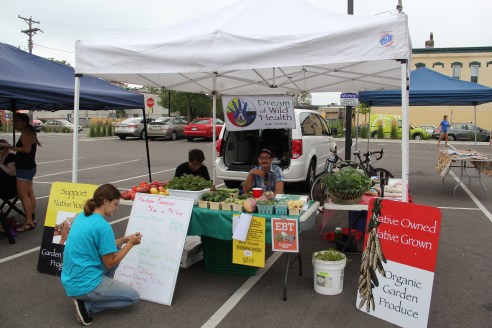 Clara, Jonathan, and Aidan at the DOWH farmers market table set up at Open Streets on Franklin Ave. Photo by Angelo Bacaa