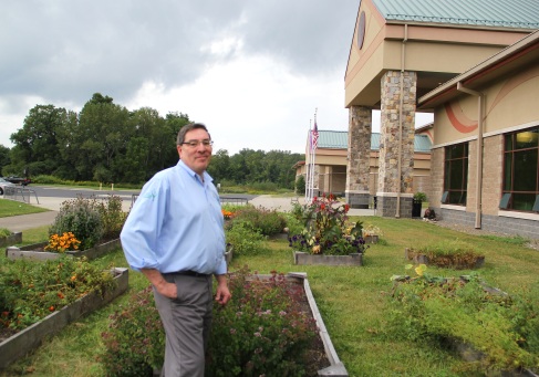 Ken Parker and the raised bed community garden in front of the Cattaraugus Community Center. Photo by Elizabeth Hoover