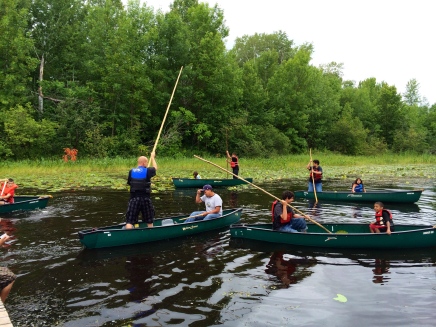 Learning how to use a pole to move the canoe slowly along. Photo by Elizabeth Hoover