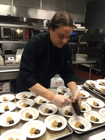 Sean scraping burnt corn over the corn cakes and meat and berry cakes. Photo by Elizabeth Hoover