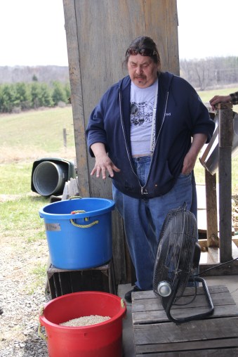 Ted Skennandore (Oneida), demonstrating winnowing corn, to blow away chaff from the kernels that will become food or be saved for seed. Photo by Elizabeth Hoover